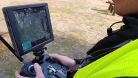 policjant - operator drona, z wizjerem w dłoniach