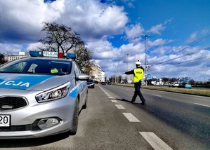 policjant zatrzymuje samochód do kontroli drogowej
