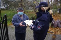 policjantka rozdaje seniorom materiały profilaktyczne