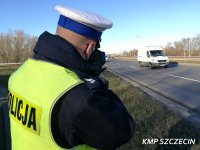policjant mierzy prędkość pojazdów na drodze