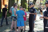 Przy wejściu na plażę w Mielnie policjanci rozmawiąją z turystami o bezpieczeństwie