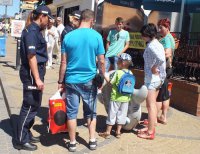 Przy wejściu na plażę w Mielnie policjanci rozmawiąją z turystami o bezpieczeństwie