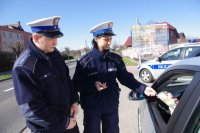 policjantka wręcza ulotkę kierowcy